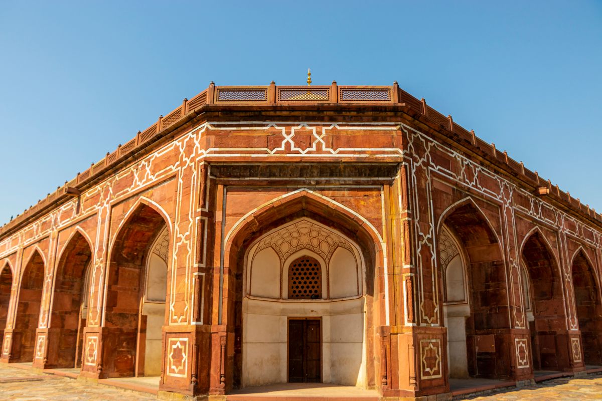 Medieval madrasa ruins beside the Hauz Khas lake at golden hour